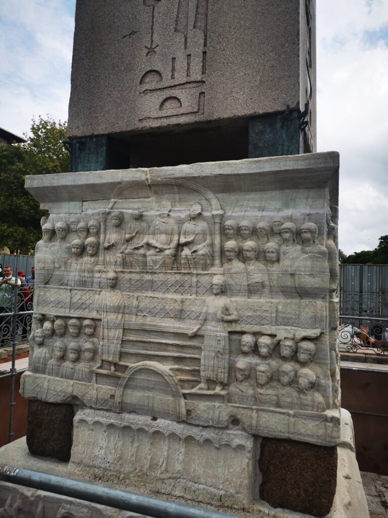 En la base del obelisco se puede ver al emperador Teodosio I con su familia; al emperador entregando la corona de la victoria a los ganadores de las carreras de carros y otros escenas de la vida de entonces.
